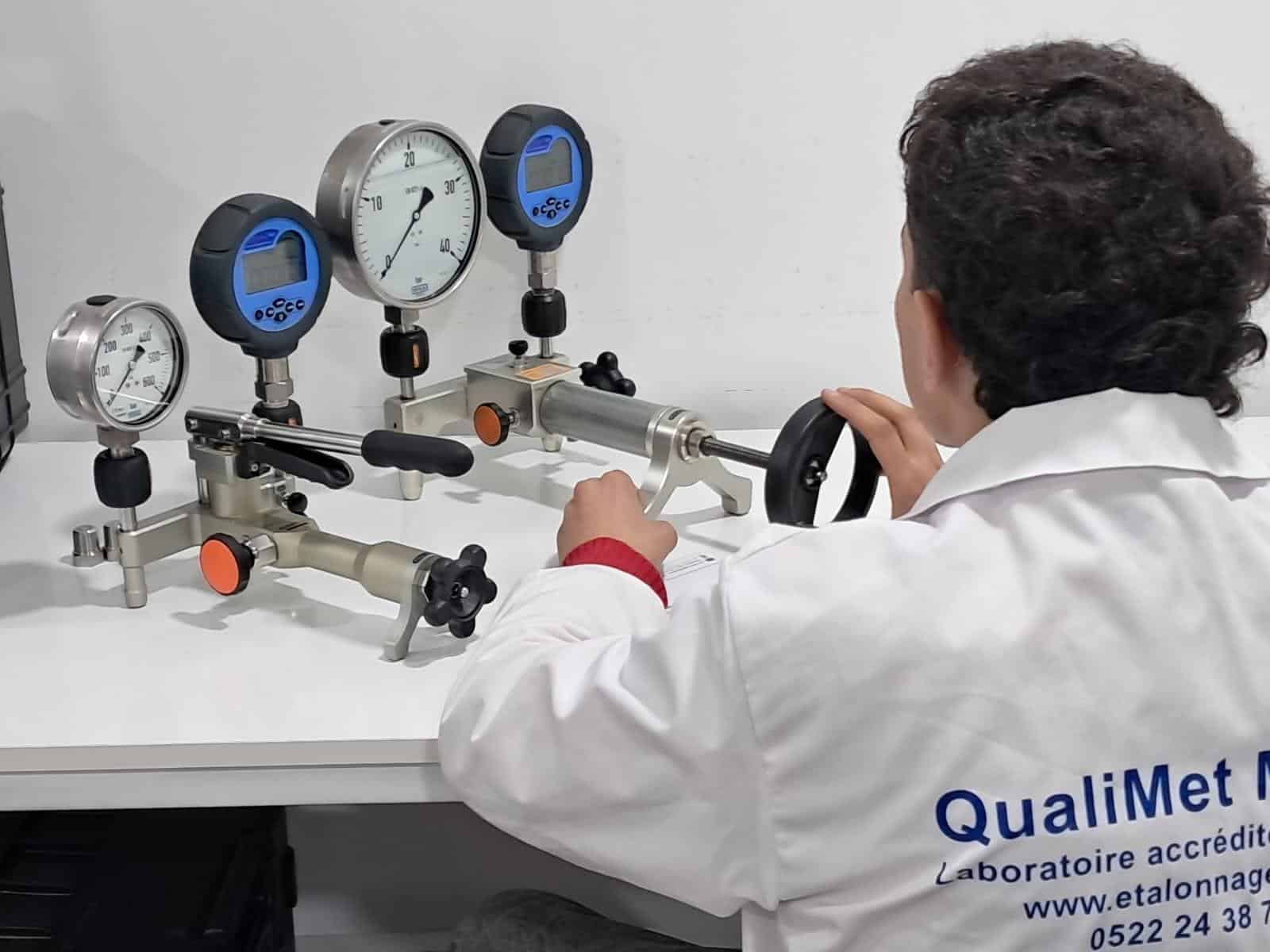 Technicien QualiMet réalisant l'étalonnage d'un manomètre sur banc de pression en laboratoire accrédité à Casablanca